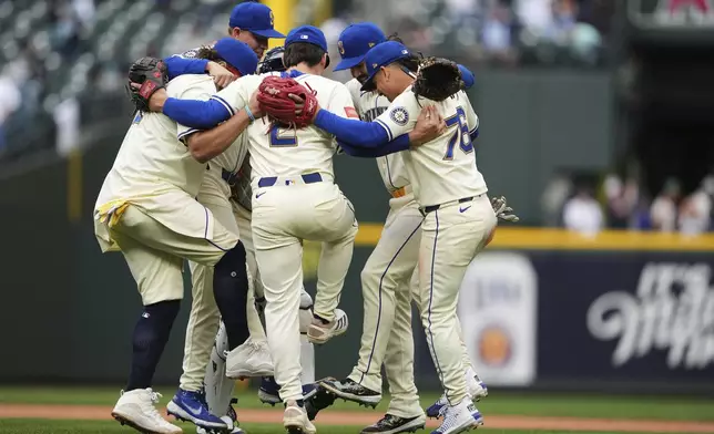The Seattle Mariners infield, including shortstop Cole Young (2) and second baseman Leo Rivas (76) celebrate a win over the Los Angeles Angels in a baseball game Sunday, Sept. 14, 2025, in Seattle. (AP Photo/Lindsey Wasson)