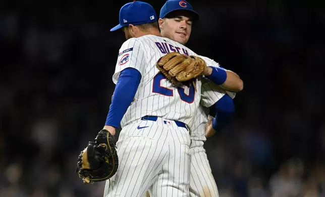 Chicago Cubs' Michael Bush (29) and Matt Shaw, back, celebrate after defeating the New York Mets in a baseball game Wednesday, Sept. 24, 2025, in Chicago. (AP Photo/Paul Beaty)