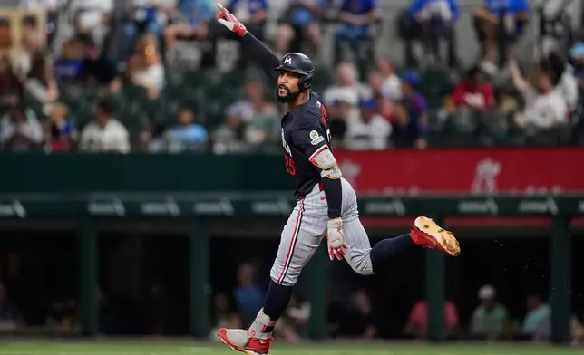 Minnesota Twins' Byron Buxton celebrate after hitting a solo home run in the first inning of a baseball game against the Texas Rangers Wednesday, Sept. 24, 2025, in Arlington, Texas. (AP Photo/Tony Gutierrez)