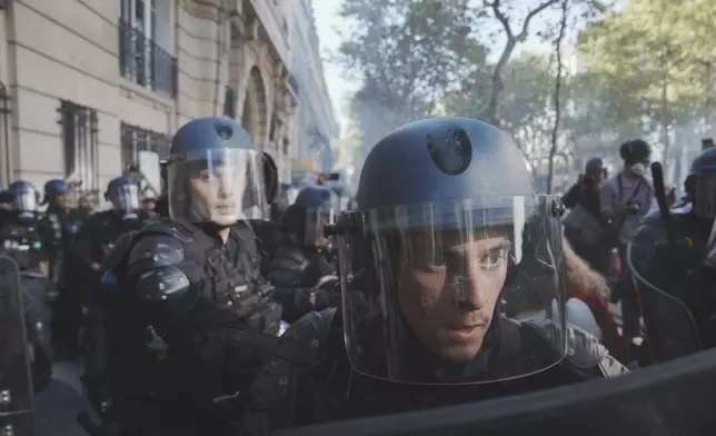 Police officers face protesters during a demonstration called by major trade unions to oppose budget cuts, in Paris, France, Thursday, Sept. 18, 2025. (AP Photo/Thibault Camus)
