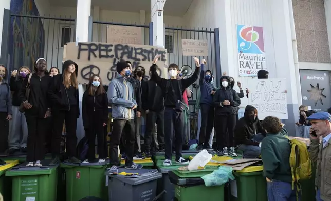 Students block the entrance of a school during a protest called by major trade unions to oppose budget cuts, in Paris, France, Thursday, Sept. 18, 2025. (AP Photo/Michel Euler)