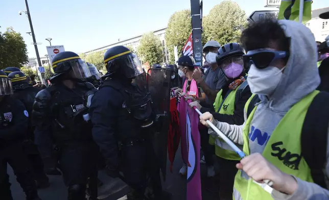 Demonstrators face police during a protest called by major trade unions to oppose budget cuts, in Nantes, western France, Thursday, Sept. 18, 2025. (AP Photo/Mathieu Pattier)