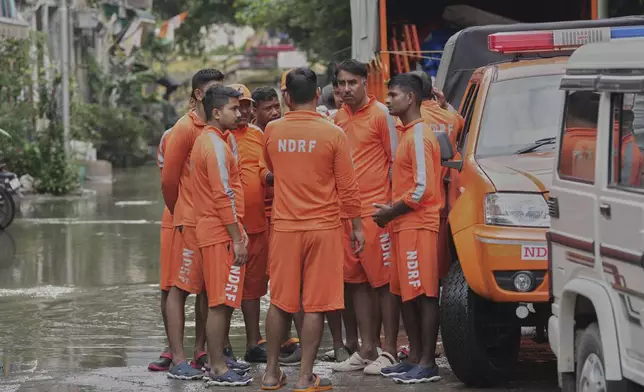 Soldiers from National Disaster Relief Force talk before starting the rescue operation after the river Yamuna, swollen by incessant rain in the higher regions, overran its banks, in New Delhi, India, Friday, Sept. 5, 2025. (AP Photo/Manish Swarup)
