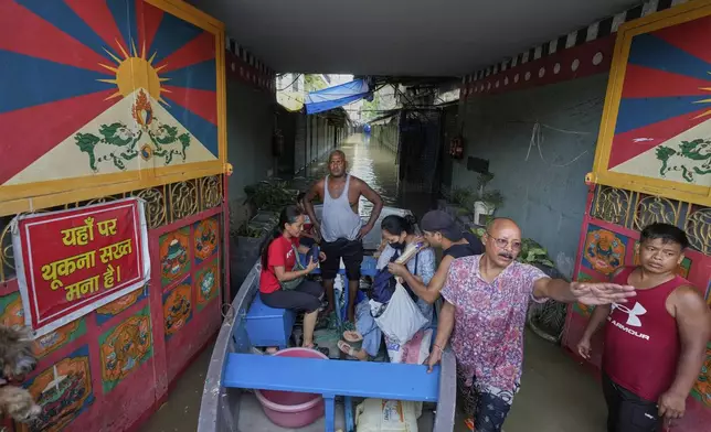 Residents of a Tibetan refugee colony use boat after the Yamuna river, swollen by incessant rain in the higher regions, overran its banks in New Delhi, India, Friday, Sept. 5, 2025. (AP Photo/Manish Swarup)