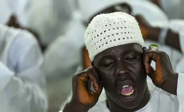 A man recites prayers as people mark Prophet Muhammad's birthday, known as Mawlid, in Dakar, Senegal, Friday, Sept. 5, 2025. (AP Photo/Misper Apawu)