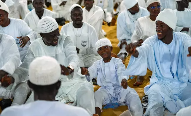 A boy sings and gestures among other worshippers as people mark Prophet Muhammad's birthday, known as Mawlid, in Dakar, Senegal, Friday, Sept. 5, 2025. (AP Photo/Misper Apawu)