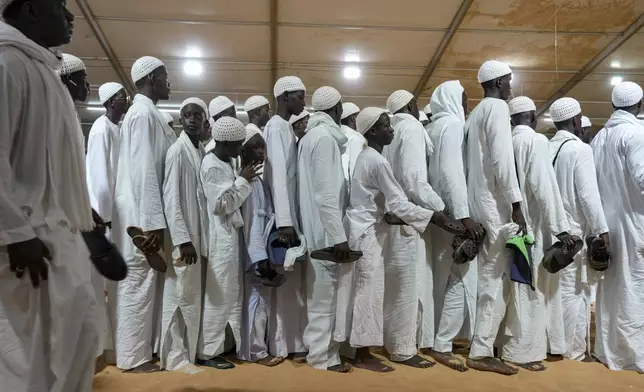 Men and boys in white robes gather for night prayers as they mark Prophet Muhammad's birthday, known as Mawlid, in Dakar, Senegal, Thursday, Sept 4, 2025. (AP Photo/Misper Apawu)