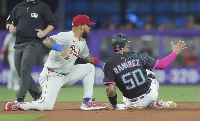 Philadelphia Phillies second baseman Edmundo Sosa tags Miami Marlins' Agustín Ramírez (50) as he tries to steal the base during the first inning of a baseball game Saturday, Sept. 6, 2025, in Miami. (AP Photo/Marta Lavandier)