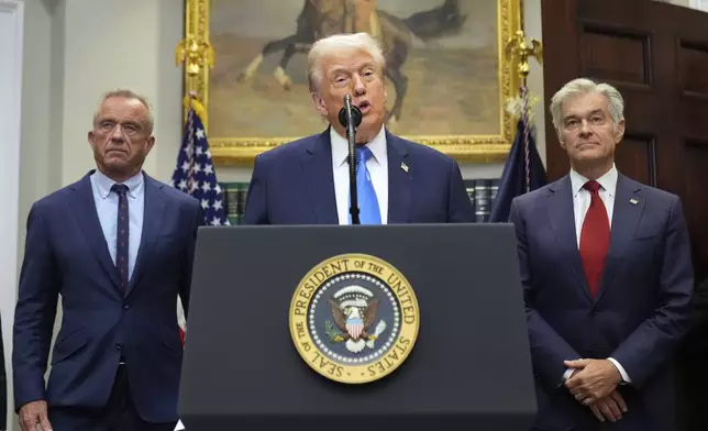 President Donald Trump speaks in the Roosevelt Room of the White House, Monday, Sept. 22, 2025, in Washington, as Health and Human Services Secretary Robert F. Kennedy Jr., left, and Centers for Medicare &amp; Medicaid Services administrator Dr. Mehmet Oz listen. (AP Photo/Mark Schiefelbein)