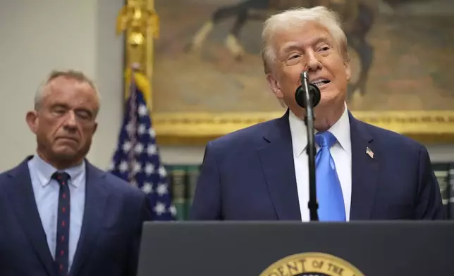 President Donald Trump speaks in the Roosevelt Room of the White House, Monday, Sept. 22, 2025, in Washington, as Health and Human Services Secretary Robert F. Kennedy Jr. listens. (AP Photo/Mark Schiefelbein)