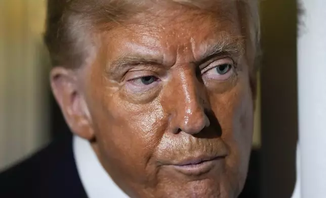 President Donald Trump speaks to reporters aboard Air Force One while en route to Joint Base Andrews, Md. after attending a memorial for conservative activist Charlie Kirk in Glendale, Ariz., Sunday, Sept. 21, 2025. (AP Photo/Julia Demaree Nikhinson)