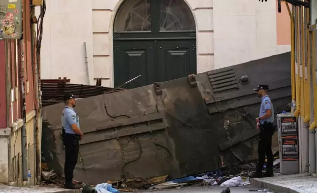 Police officers cordon off the area where a tourist streetcar derailed and crashed in Lisbon, Portugal, Thursday, Sept. 4, 2025. (AP Photo/Armando Franca)