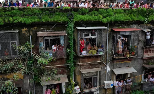 People watch as an idol of elephant-headed Hindu god Ganesha is taken for immersion on the final day of the ten-day long Ganesh Chaturthi festival in Mumbai, India, Saturday, Sept. 6, 2025. (AP Photo/Rajanish Kakade)