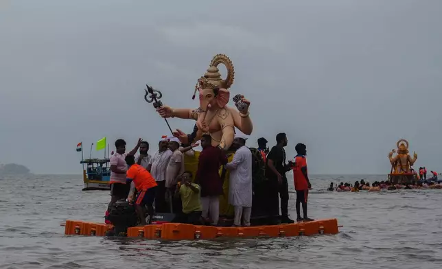 Devotees prepare to immerse a giant idols of elephant-headed Hindu god Ganesha in the Arabian Sea, marking the end of the 10-day long Ganesh Chaturthi festival in Mumbai , India, Saturday, Sept. 6, 2025. (AP Photo/Rafiq Maqbool)