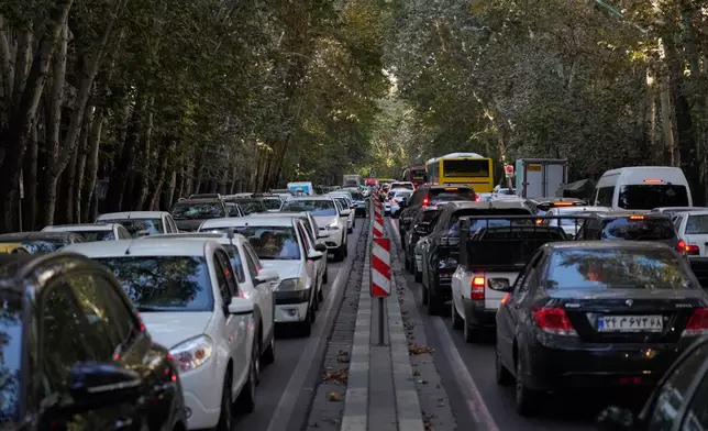 People commute in their cars during an afternoon traffic jam in northern Tehran, Iran, Sunday, Sept. 28, 2025. (AP Photo/Vahid Salemi)