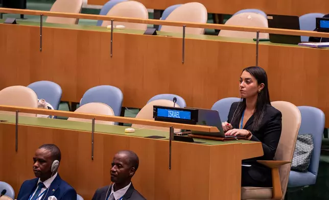 A woman from the delegation of Israel watches Palestinian President Mahmoud Abbas address the 80th session of the United Nations General Assembly via video at United Nations headquarters, Thursday, Sept. 25, 2025. (AP Photo/Angelina Katsanis)