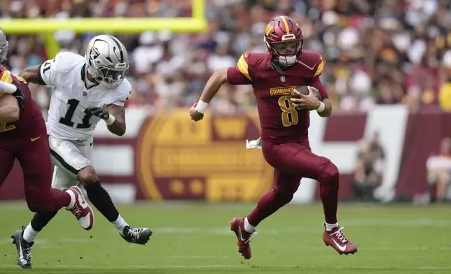Washington Commanders quarterback Marcus Mariota (8) runs with the ball during the first half of NFL football game against the Las Vegas Raiders, Sunday, Sept. 21, 2025, in Landover, Md. (AP Photo/Stephanie Scarbrough)