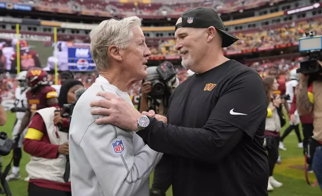 Las Vegas Raiders Pete Carroll, left, and Washington Commanders Dan Quinn talk after an NFL football game Sunday, Sept. 21, 2025, in Landover, Md. (AP Photo/Stephanie Scarbrough)