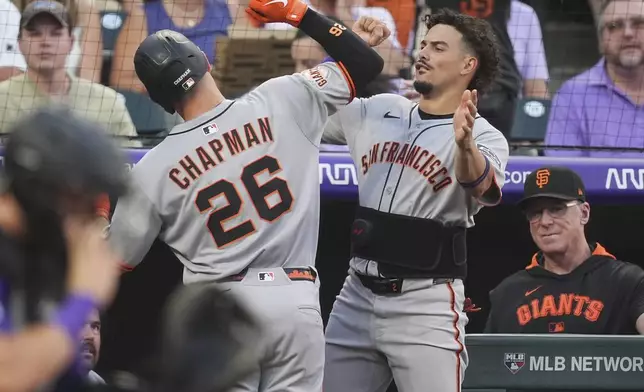 San Francisco Giants' Willy Adames, right, congratulates Matt Chapman (26) as he returns to the dugout after hitting a solo home run off Colorado Rockies starting pitcher Germán Márquez in the second inning of a baseball game Wednesday, Sept. 3, 2025, in Denver. (AP Photo/David Zalubowski)