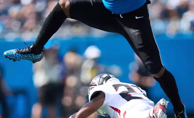 FILE - Carolina Panthers tight end Ja'Tavion Sanders (0) leaps over Atlanta Falcons cornerback Mike Hughes (21) during an NFL football game, Sunday Sep. 21, 2025, in Charlotte, N.C. (AP Photo/Brian Westerholt)