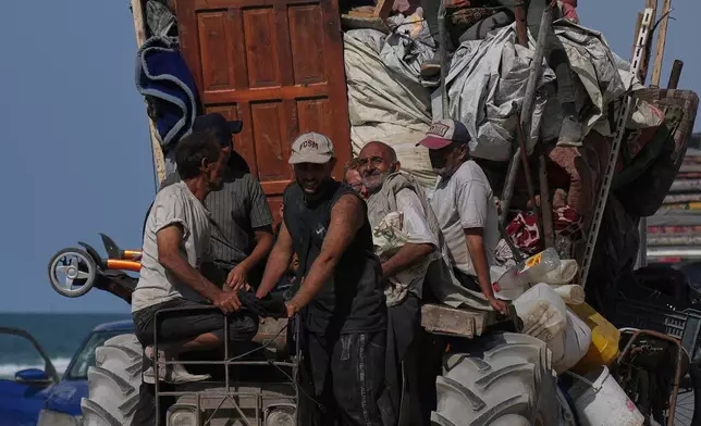 FILE - Displaced Palestinians flee northern Gaza Strip on top of a vehicle carrying their belongings along the coastal road near Wadi Gaza, Monday, Sept. 22, 2025. (AP Photo/Abdel Kareem Hana)