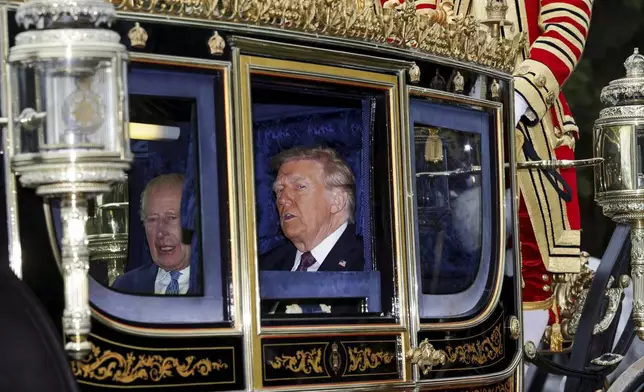 Britain's King Charles, left, and President Donald Trump sit in a carriage during a procession through Windsor Castle, England, Wednesday, Sept. 17, 2025. (Toby Melville/Pool Photo via AP)
