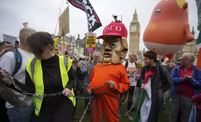 A protester wears a jail costume with a Trump mask during a demonstration of the Stop Trump Coalition group against President Donald Trump's state visit in London, Wednesday, Sept. 17, 2025.(AP Photo/Kin Cheung)