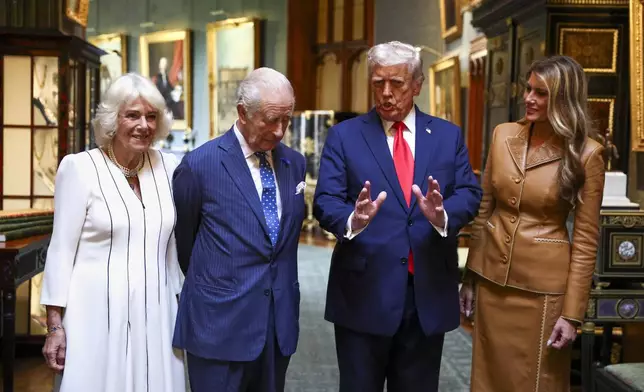 President Donald Trump speaks as he stands next to first lady Melania Trump, right, and Britain's King Charles III and Queen Camilla as they bid their farewells while they depart Windsor Castle, in Windsor, England, Thursday, Sept. 18, 2025. (Kevin Lamarque/Pool Photo via AP)