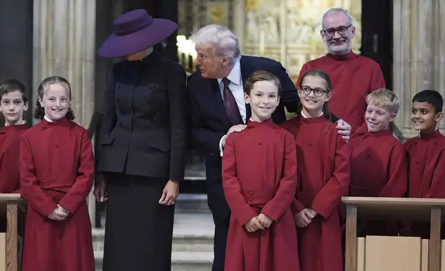 President Donald Trump and first lady Melania Trump pose with a childrens choir as they receive a tour of St. George's Chapel at Windsor Castle, Windsor, England, Wednesday, Sept. 17, 2025. (AP Photo/Evan Vucci, Pool)