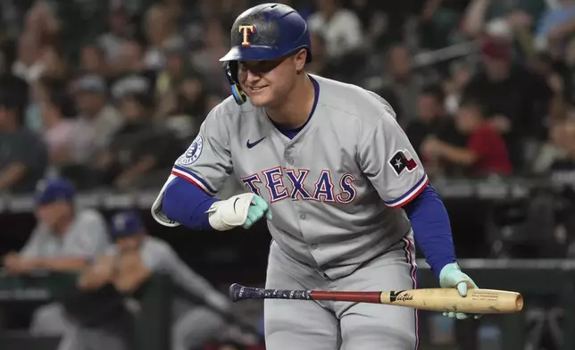 Texas Rangers' Joc Pederson acknowledges the Arizona Diamondbacks dugout in the first inning of a baseball game, Monday, Sept. 1, 2025, in Phoenix. (AP Photo/Rick Scuteri)