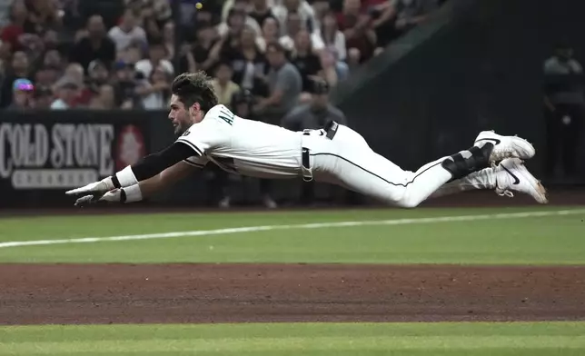 Arizona Diamondbacks' Blaze Alexander dives into third base after hitting an RBI triple against the Texas Rangers in the sixth inning of a baseball game, Monday, Sept. 1, 2025, in Phoenix. (AP Photo/Rick Scuteri)