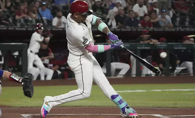 Arizona Diamondbacks' Ketel Marte hits a solo home run against the Texas Rangers in the first inning of a baseball game, Monday, Sept. 1, 2025, in Phoenix. (AP Photo/Rick Scuteri)