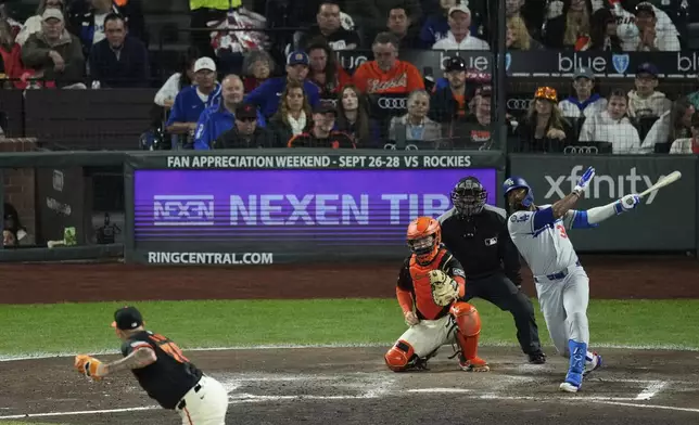 Los Angeles Dodgers' Teoscar Hernández, right, hits a two-run double during the fifth inning of a baseball game against the San Francisco Giants, Saturday, Sept. 13, 2025, in San Francisco. (AP Photo/Godofredo A. Vásquez)