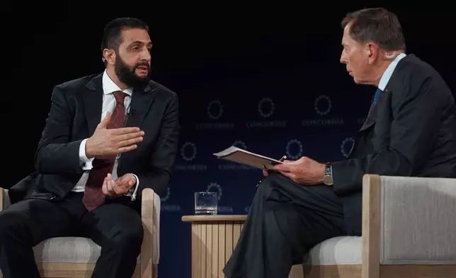Syrian President Ahmed al-Sharaa, left, speaks with former United States Army General David Howell Petraeus, right, during the Concordia Annual Summit, in New York, Monday, Sept. 22, 2025. (AP Photo/Andres Kudacki)