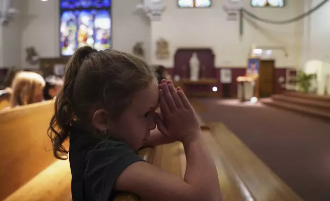 A student at St. John Berchmans' school kneels to pray during Mass at Blessed Carlo Acutis Parish on Wednesday, Sept. 3, 2025, in Chicago. (AP Photo/Jessie Wardarski)