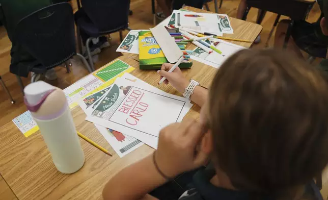Fifth grade students at St. John Berchmans' school draw pictures of Blessed Carlo Acutis, who will be canonized a saint by Pope Leo XIV, during a class activity on Wednesday, Sept. 3, 2025, in Chicago. (AP Photo/Jessie Wardarski)