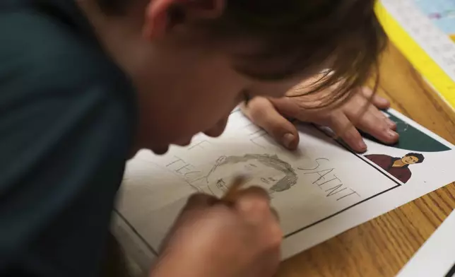 Alex Miller, a fifth-grade student at St. John Berchmans' school draws a picture of Blessed Carlo Acutis, who will be canonized a saint by Pope Leo XIV, during a class activity on Wednesday, Sept. 3, 2025, in Chicago. (AP Photo/Jessie Wardarski)