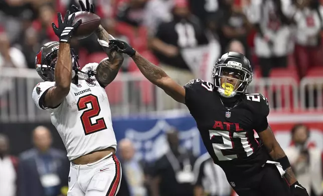 Tampa Bay Buccaneers wide receiver Emeka Egbuka (2) scores a touchdown against Atlanta Falcons cornerback Mike Hughes (21) during the second half of an NFL football game, Sunday, Sept. 7, 2025, in Atlanta. (AP Photo/Danny Karnik)