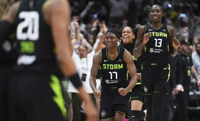 Seattle Storm guard Erica Wheeler (17) and forward Ezi Magbegor (13) run to greet teammates as the final buzzer rings and they beat the Las Vegas Aces in Game 2 in the first round of the WNBA basketball playoffs Tuesday, Sept. 16, 2025, in Seattle. (AP Photo/Lindsey Wasson)