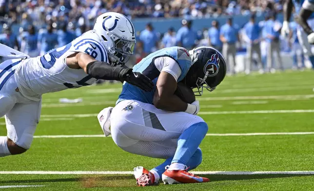 Tennessee Titans wide receiver Elic Ayomanor (5) makes a catch for a touchdown under Indianapolis Colts linebacker Austin Ajiake (58) during the second half of an NFL football game Sunday, Sept. 21, 2025, in Nashville, Tenn. (AP Photo/John Amis)
