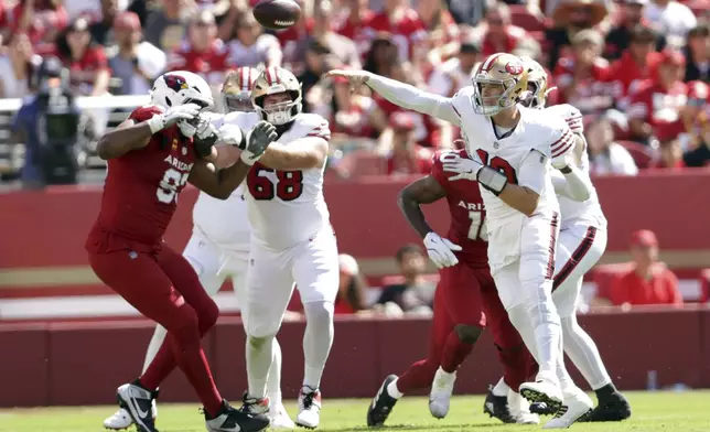 San Francisco 49ers' Mac Jones, front right, passes the ball in the second quarter of an NFL football game against the Arizona Cardinals in Santa Clara, Calif., Sunday, Sept. 21, 2025. (Scott Strazzante/San Francisco Chronicle via AP)
