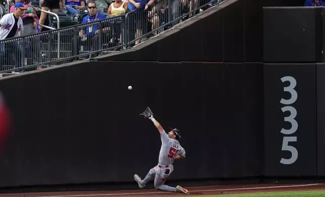 Washington Nationals outfielder Daylen Lile attempts to catch a fly ball by New York Mets' Cedric Mullins during the third inning of a baseball game against the New York Mets, Sunday, Sept. 21, 2025, in New York. (AP Photo/Yuki Iwamura)