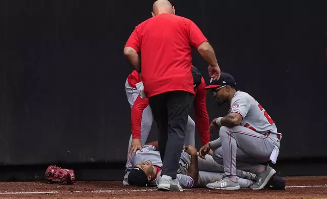Washington Nationals outfielder Daylen Lile reacts after hitting a wall while failing to catch a fly ball by New York Mets' Cedric Mullins during the third inning of a baseball game against the New York Mets, Sunday, Sept. 21, 2025, in New York. (AP Photo/Yuki Iwamura)