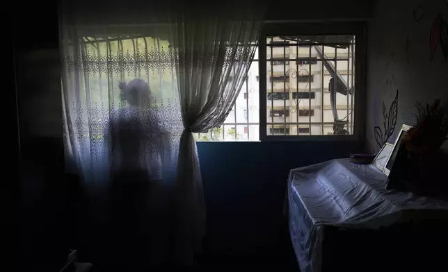 Syntia Caceres looks out the window of her home while talking about her four-year-old granddaughter Aurore, who was placed in foster care in the U.S. state of Georgia after her son was detained in July, in Caracas, Venezuela, Thursday, 4, 2025. (AP Photo/Ariana Cubillos)