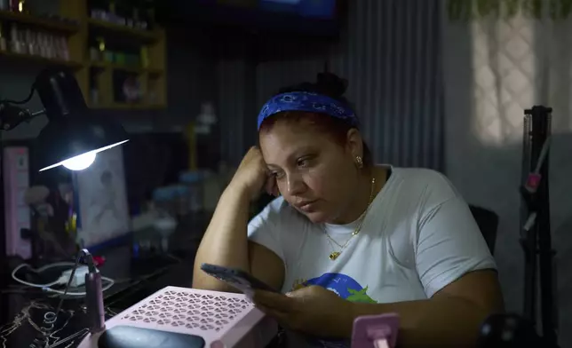 Syntia Caceres talks on the phone to her son, who was detained in the U.S. in July and her four-year-old granddaughter Aurore was placed in foster care in Georgia state, at her home in Caracas, Venezuela, Thursday, Sept. 4, 2025. (AP Photo/Ariana Cubillos)