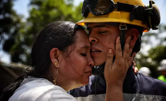 Yuliana Andrea Agudelo embraces her son Sebastian Agudelo after he was rescued from a gold mine that had collapsed trapping over 20 miners, in Segovia, Colombia, Wednesday, Sept. 24, 2025. (AP Photo/Santiago Saldarriaga)