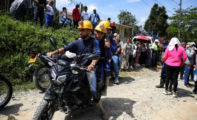 Miners ride off on a motorcycle after they were rescued from a gold mine they were working in had collapsed in Segovia, Colombia, Wednesday, Sept. 24, 2025. (AP Photo/Santiago Saldarriaga)