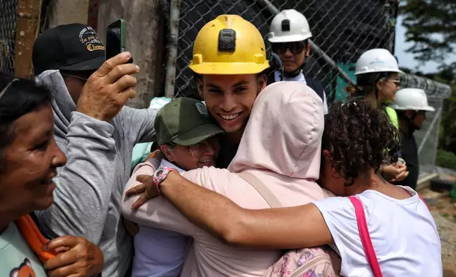 A miner embraces family members after he was rescued from a gold mine that collapsed, in Segovia, Colombia, Wednesday, Sept. 24, 2025. (AP Photo/Santiago Saldarriaga)