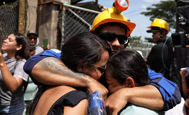 A miner embraces his relatives after he was rescued from a gold mine that had collapsed in Segovia, Colombia, Wednesday, Sept. 24, 2025. (AP Photo/Santiago Saldarriaga)
