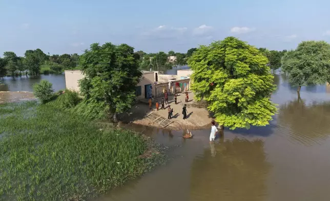 Villagers gather outside their homes, which are surrounding by floodwaters, in Tiba Gheal village, in Jhang district, Pakistan, Tuesday, Sept. 2, 2025. (AP Photo/Jahan Zeb)